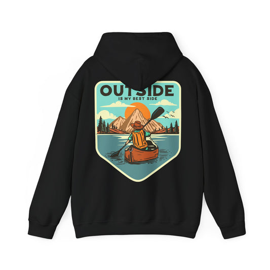 Sophisticated black hoodie showcasing a vintage-style print of a kayaker adventurously paddling on a tranquil lake, framed by breathtaking mountains at sunrise, with the phrase 'OUTSIDE IS MY BEST SIDE' elegantly highlighted.