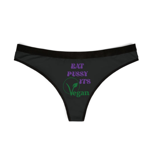 Luxurious black thong panties showcasing a playful statement 'EAT PUSSY, IT'S VEGAN' in bold purple and green lettering, blending humour with eco-conscious fashion.