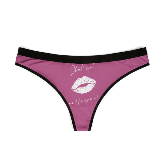 Luxurious women's thong featuring a playful design with the phrase 'Shut up! and kiss me!' adorned with a kiss silhouette, in elegant pink with a contrasting black waistband.