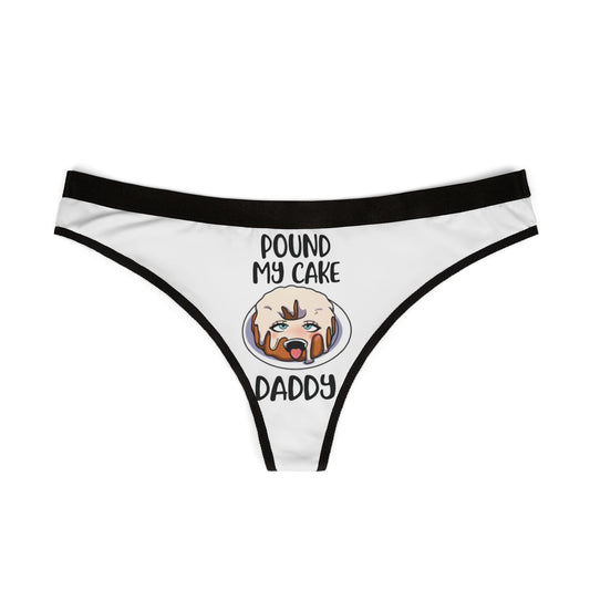 Front view of a white women's thong adorned with the cheeky phrase 'POUND MY CAKE DADDY' and a delightful cake illustration, ideal for romantic gifts and unique lingerie collections.