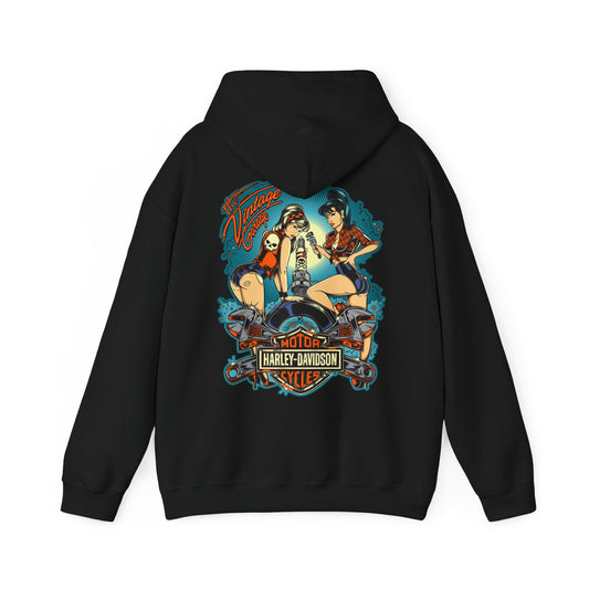 Chic black vintage garage hoodie showcasing an eye-catching back design of pin-up women and a motorcycle, surrounded by whimsical elements, perfect for the fashion-forward individual.