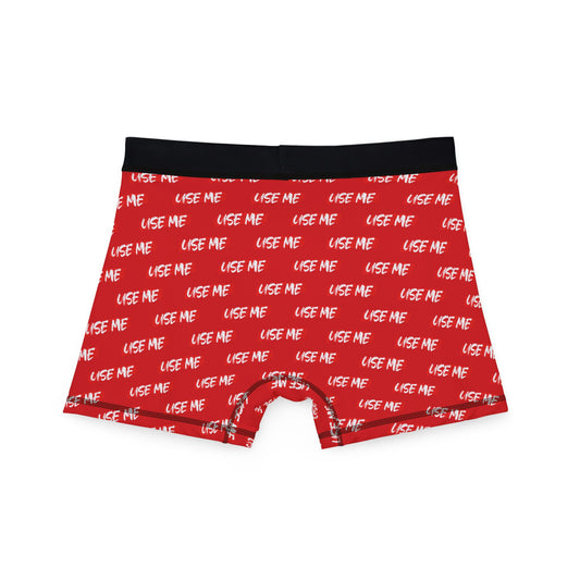 Rear view of vibrant red men's boxer briefs showcasing the humorous 'USE ME' pattern, perfect for adding a playful touch to intimate moments.