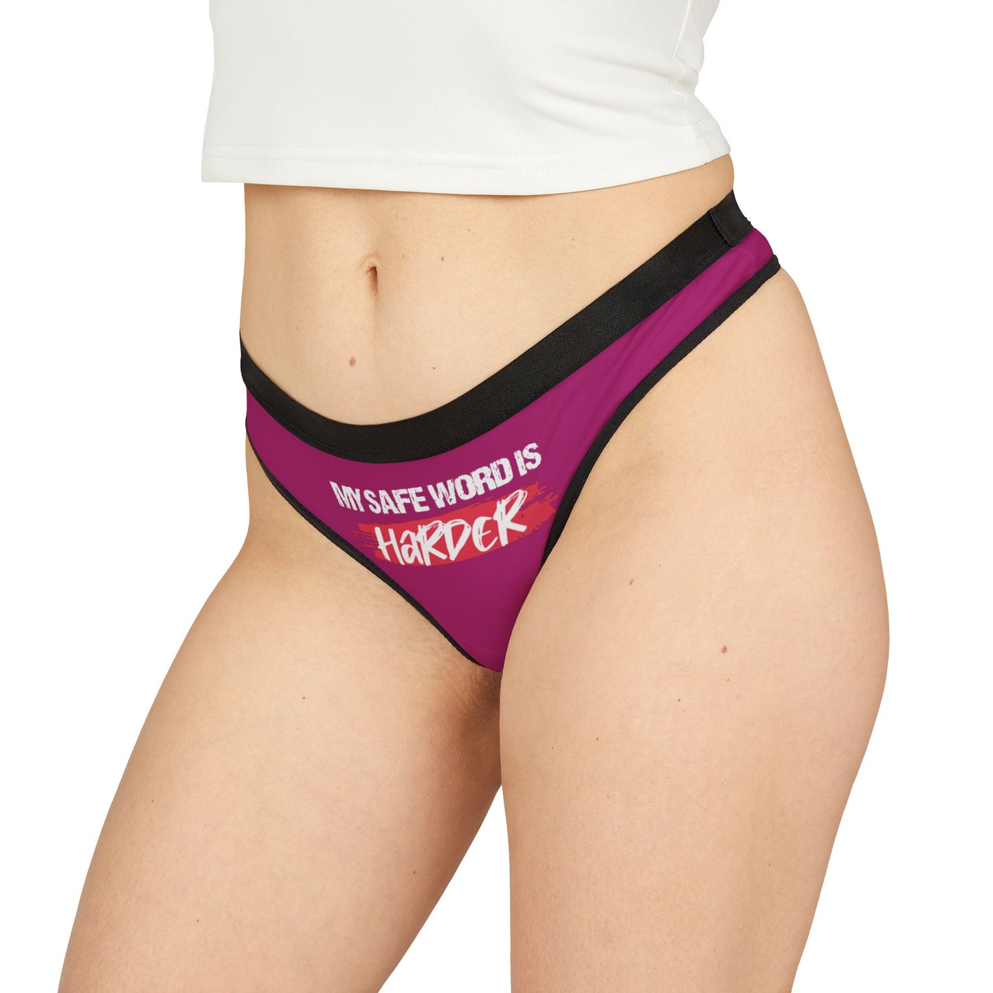 Side angle of a luxurious cheeky thong in pink, prominently displaying the cheeky slogan 'MY SAFE WORD IS HARDER', ideal for adding a playful edge to lingerie collections.