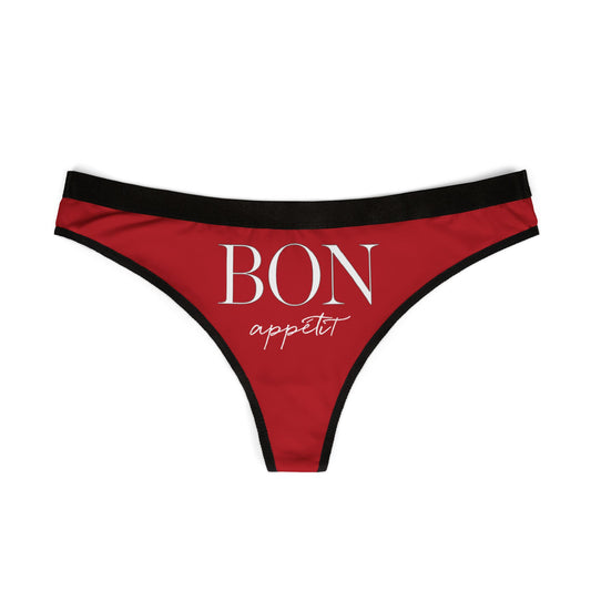 Chic red women's thong displaying the stylish phrase 'BON appétit' in sophisticated font, accented with a refined black trim, ideal for luxurious gifting on special occasions.