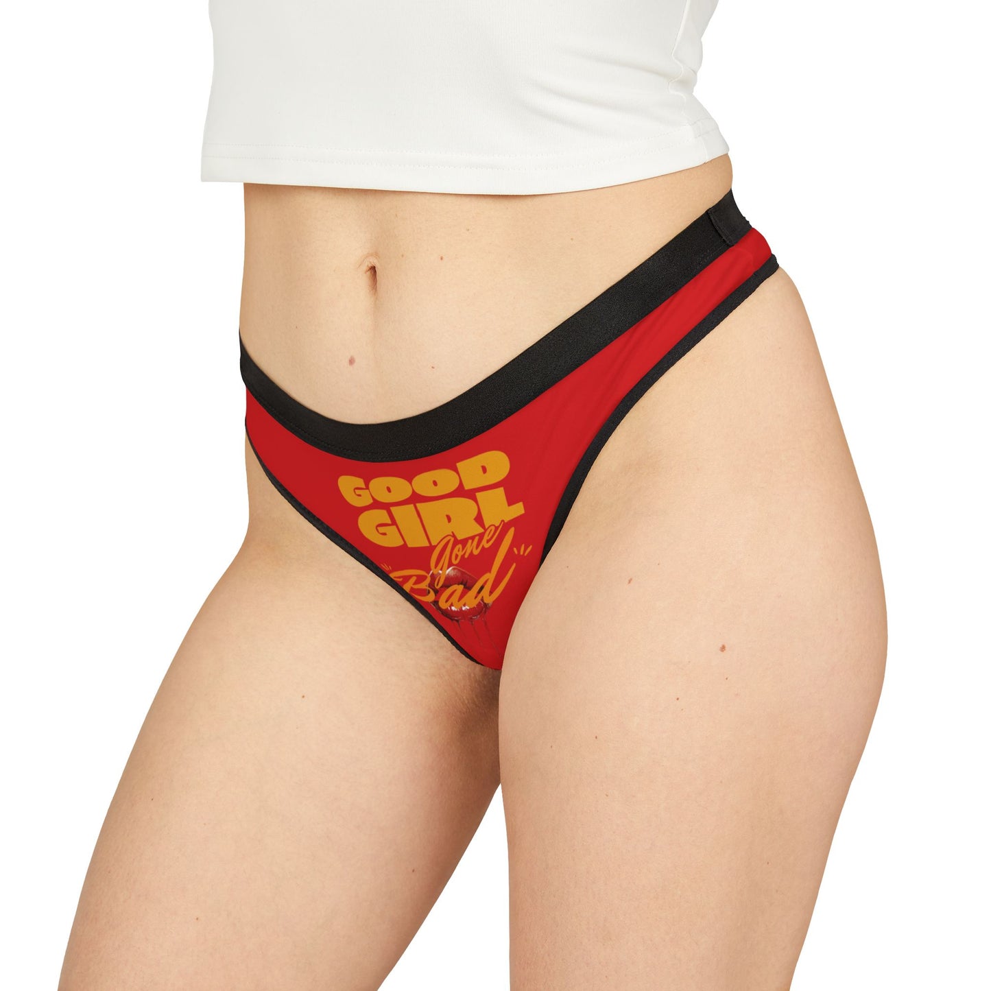Model displaying 'Good Girl Gone Bad' thong panties, showcasing the unique graphic design against a soft backdrop, exuding luxury and confidence.