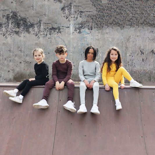 Elegant family lounging in DreamBuy's Dove Grey Matching Pyjamas, highlighting the minimalist style and soft fabric, perfect for comfort during play and sleep.