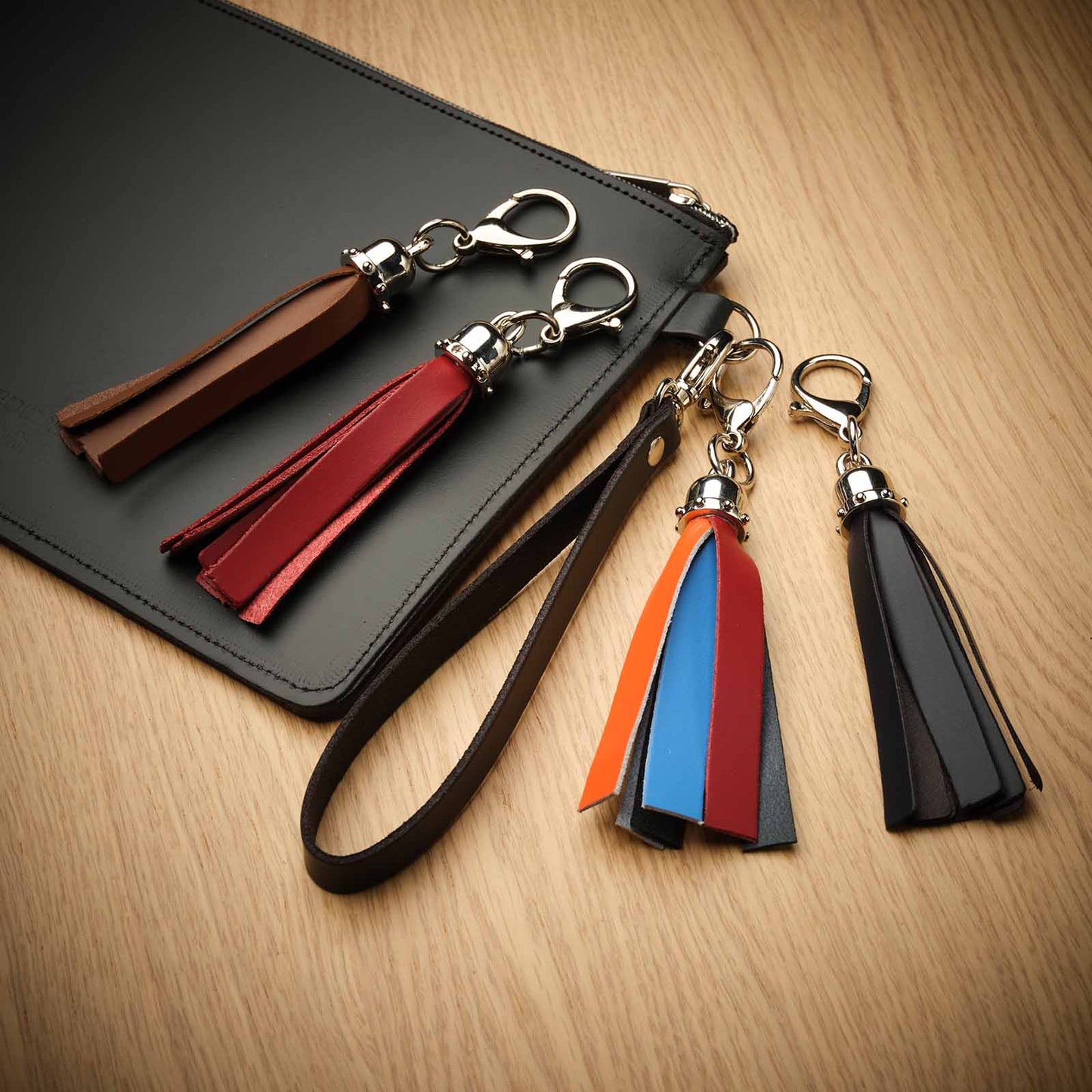 Stylish red mini tassel bag charm, expertly crafted in England, showcasing a vibrant hue that adds glamour and sophistication to any ensemble.