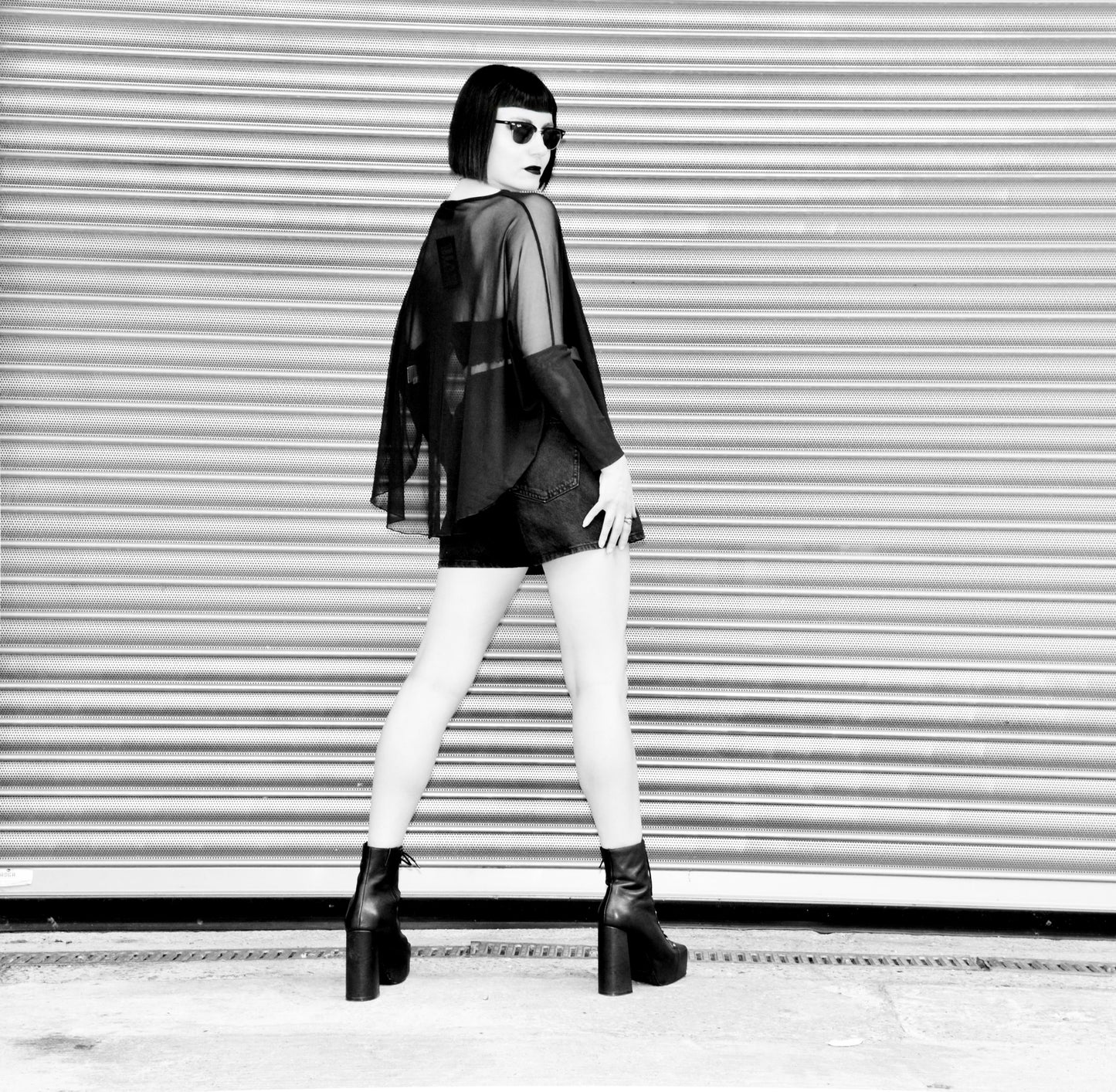 Dramatic draped silhouette of the Necessary Evil Circe Mesh Top, showcasing its luxurious lightweight mesh fabric and versatility for alternative fashion styles.