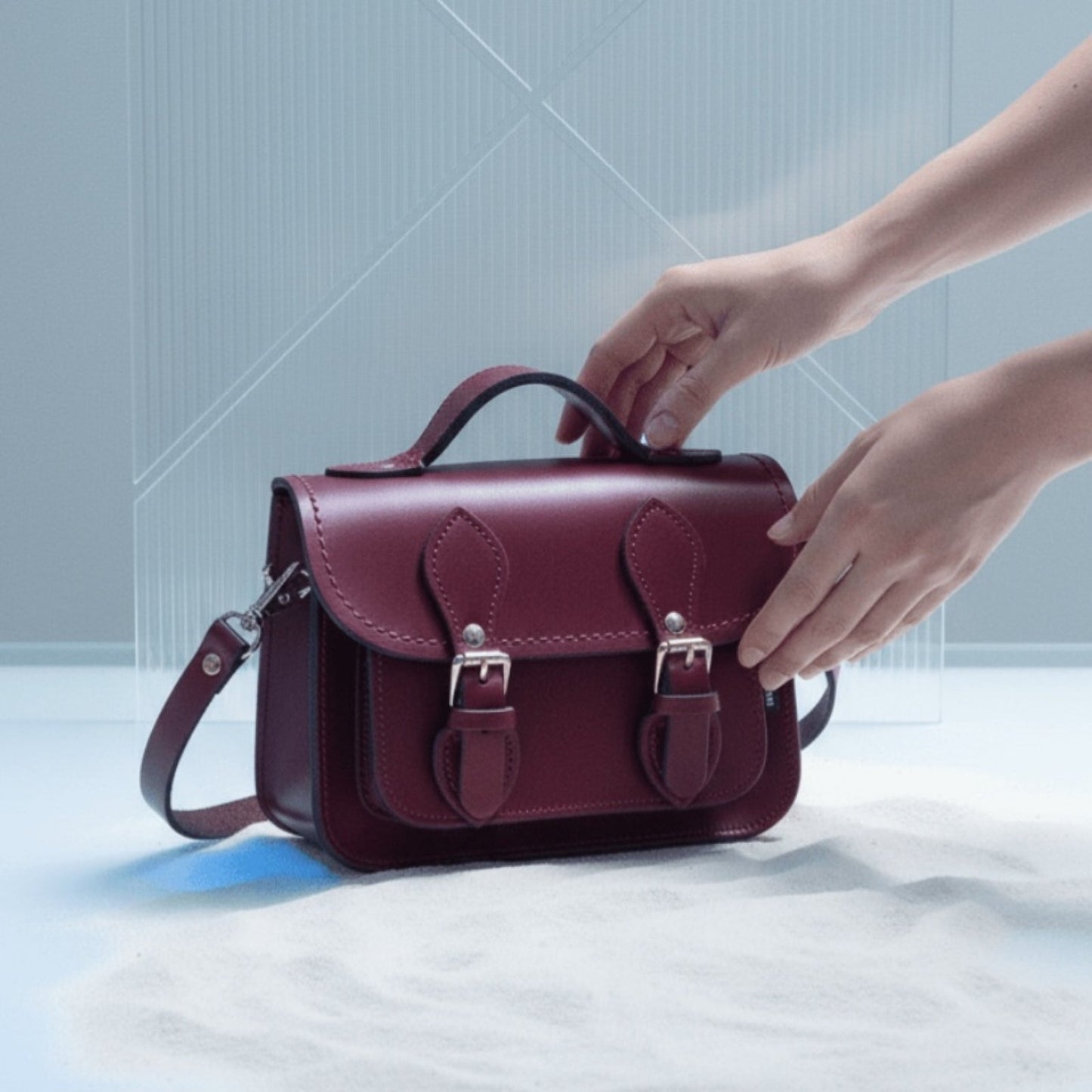 Sophisticated lifestyle shot of the oxblood leather micro satchel, demonstrating its appeal as a must-have luxury accessory for modern individuals.