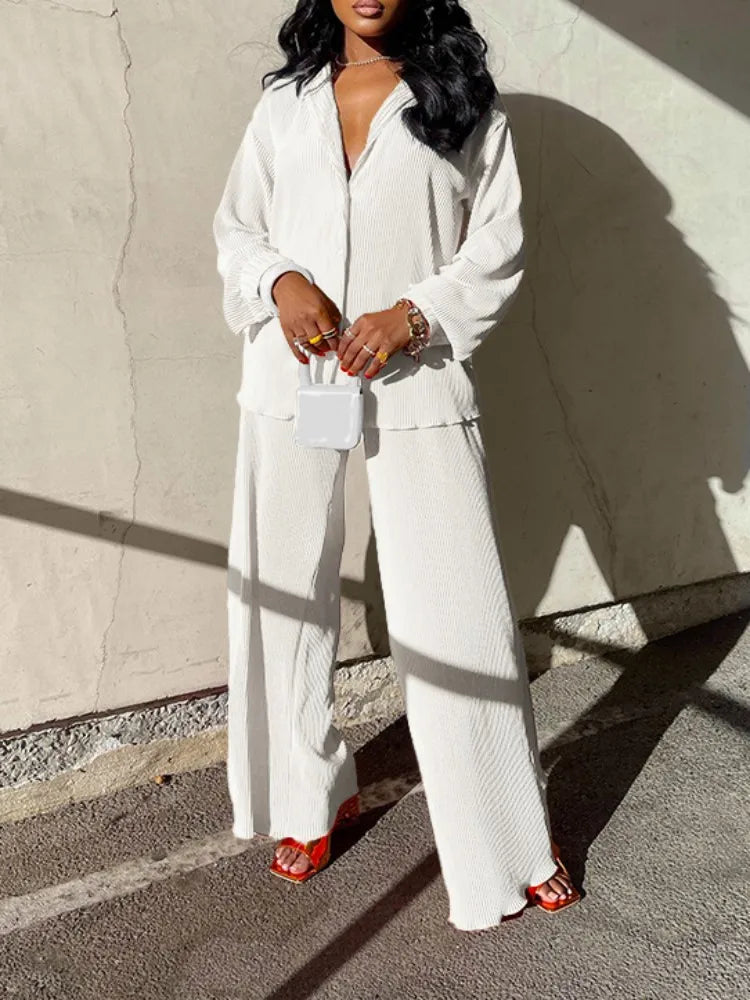 Chic flat lay of the oversized pleated shirt and high waist wide leg pants set by QFAF, emphasising luxury styling and comfort.