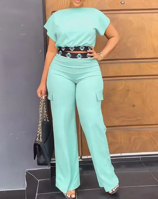 Luxury geometric print two-piece set for women, consisting of a flattering boat neck crop top and stylish high waist ankle-length trousers, designed for summer elegance.