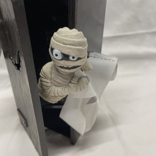 Close-up of the Spooky Outdoor Toilet Mummy Decoration, showcasing the playful mummy figure peeking out with toilet paper.