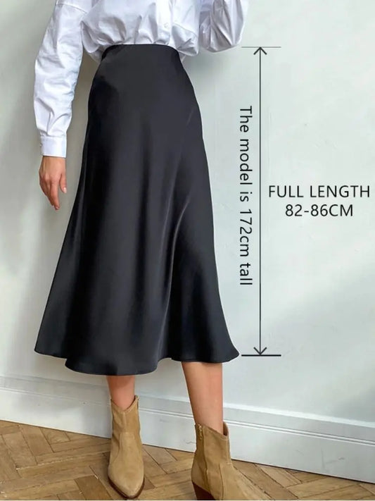 Women's High Waisted Silk Midi Skirt - A-Line Designer Fashion in Luxurious Satin, displayed on a model wearing it in a classic black shade, paired with a white shirt and stylish ankle boots.