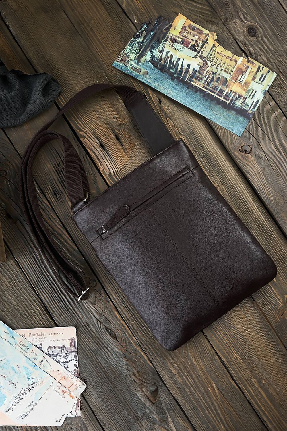 Close-up view of Galanter's aged natural leather shoulder bag, highlighting the luxurious texture and zippered compartments for a sophisticated accessory look.