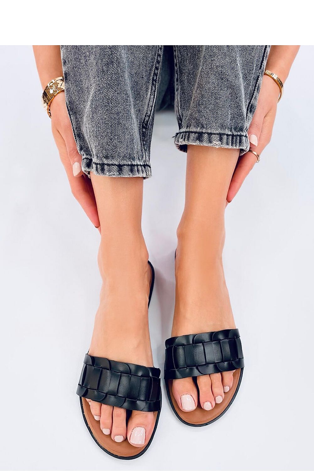 Chic black women's flip-flops by Inello with braided straps, styled elegantly, designed from eco-friendly leather for a sophisticated summer look.