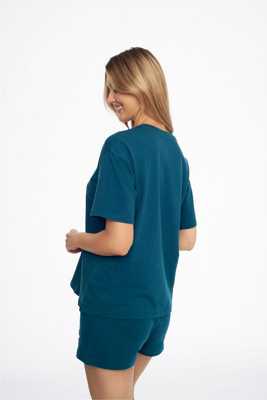 Back view of a stylish woman in Henderson women's Sea Abstract cotton pyjamas. The ensemble showcases the relaxed silhouette and soft terry fabric, ideal for luxurious lounging.