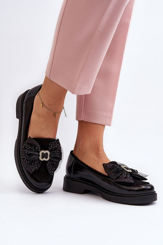 Stylish black moccasins by Step in Style with accentuated bow and glittering embellishments, paired expertly with sophisticated pink ankle trousers for a fashionable spring outfit.