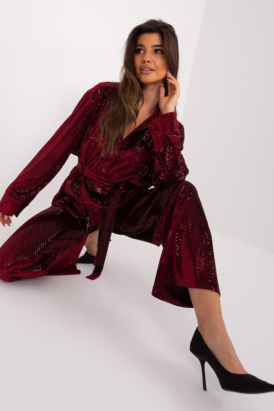 Elegant Lakerta outfit in burgundy, combining a sequinned shirt and high-waisted trousers. The model poses gracefully, highlighting the exquisite details of this formal wear set, complemented by stylish black heels.