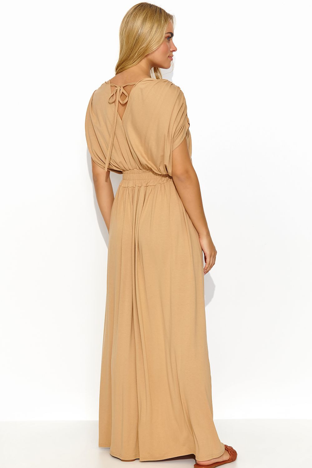 Back view of a sophisticated woman showcasing the Makadamia long lightweight knit daydress, highlighting the delicate back tie and elegant silhouette in a taupe hue.