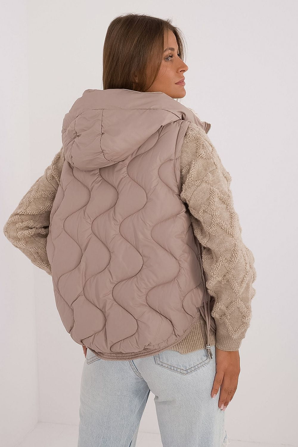 Lifestyle image of a woman wearing MBM Women's Quilted Down Vest with Hood, illustrating its versatile style and functionality for chic everyday wear.