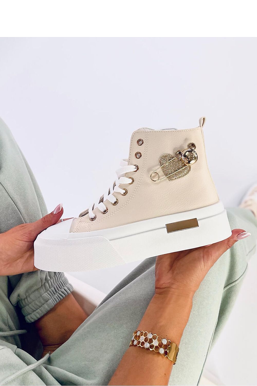 Elevated view of women's luxurious eco leather sneakers by Inello with chic gold decorations, perfect for casual or upscale occasions.