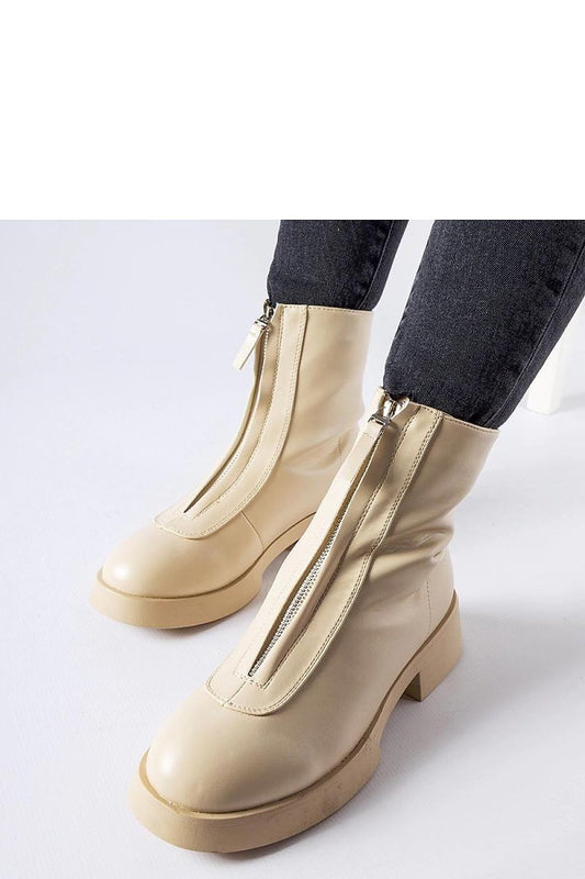 Close-up of Solea's beige insulated ankle boots, showcasing high-quality synthetic leather and practical side zippers for easy wear.