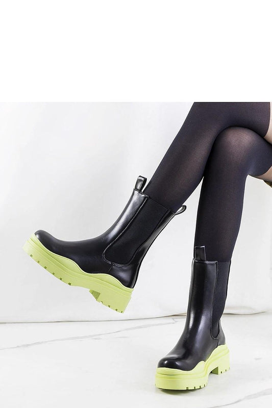 Close-up view of Solea black ankle boots with green rubber sole, highlighting the elastic inserts for a perfect fit and luxurious comfort.