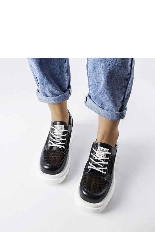 Close-up of the luxurious black perforated leather of Solea's Tasmin moccasins, showcasing the intricate design and quality craftsmanship.