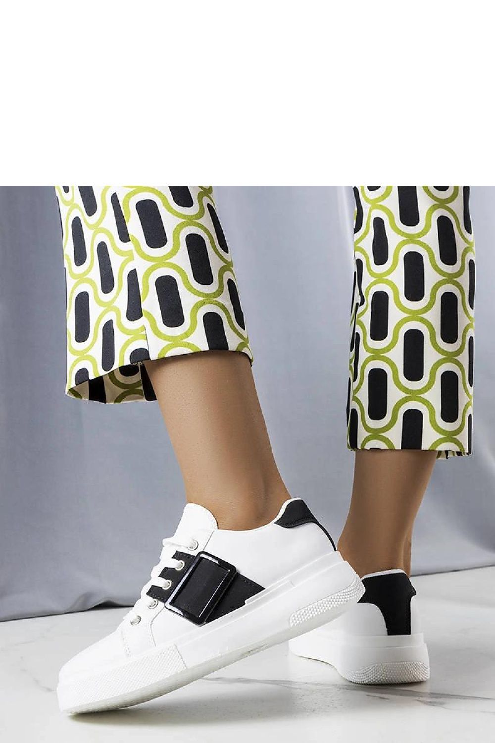 Chic luxury white sneakers with a black buckle by Solea, showcasing a sleek rubber sole for optimal grip and all-day comfort.