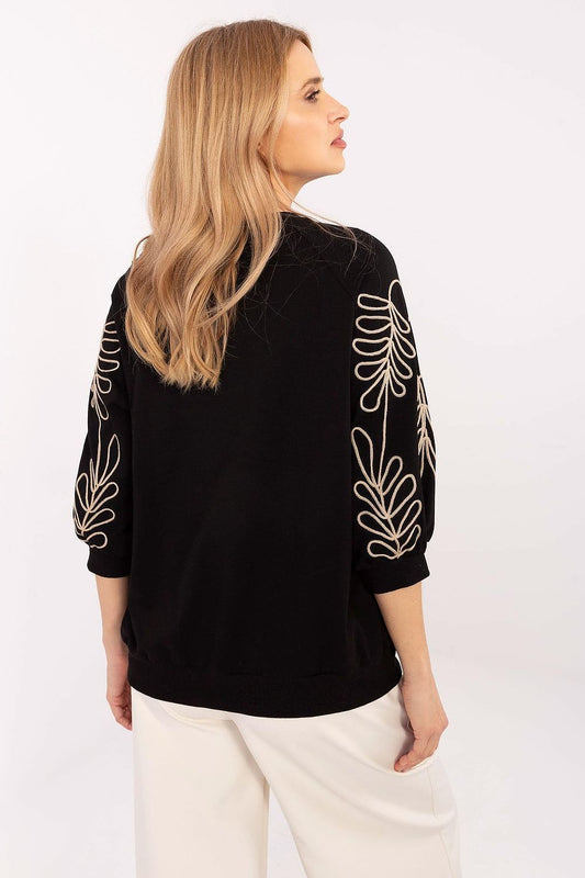 Close-up of the embroidered leaf patterns on the Relevance 3/4 Sleeve Sweatshirt for women, showcasing its luxurious design and detail.