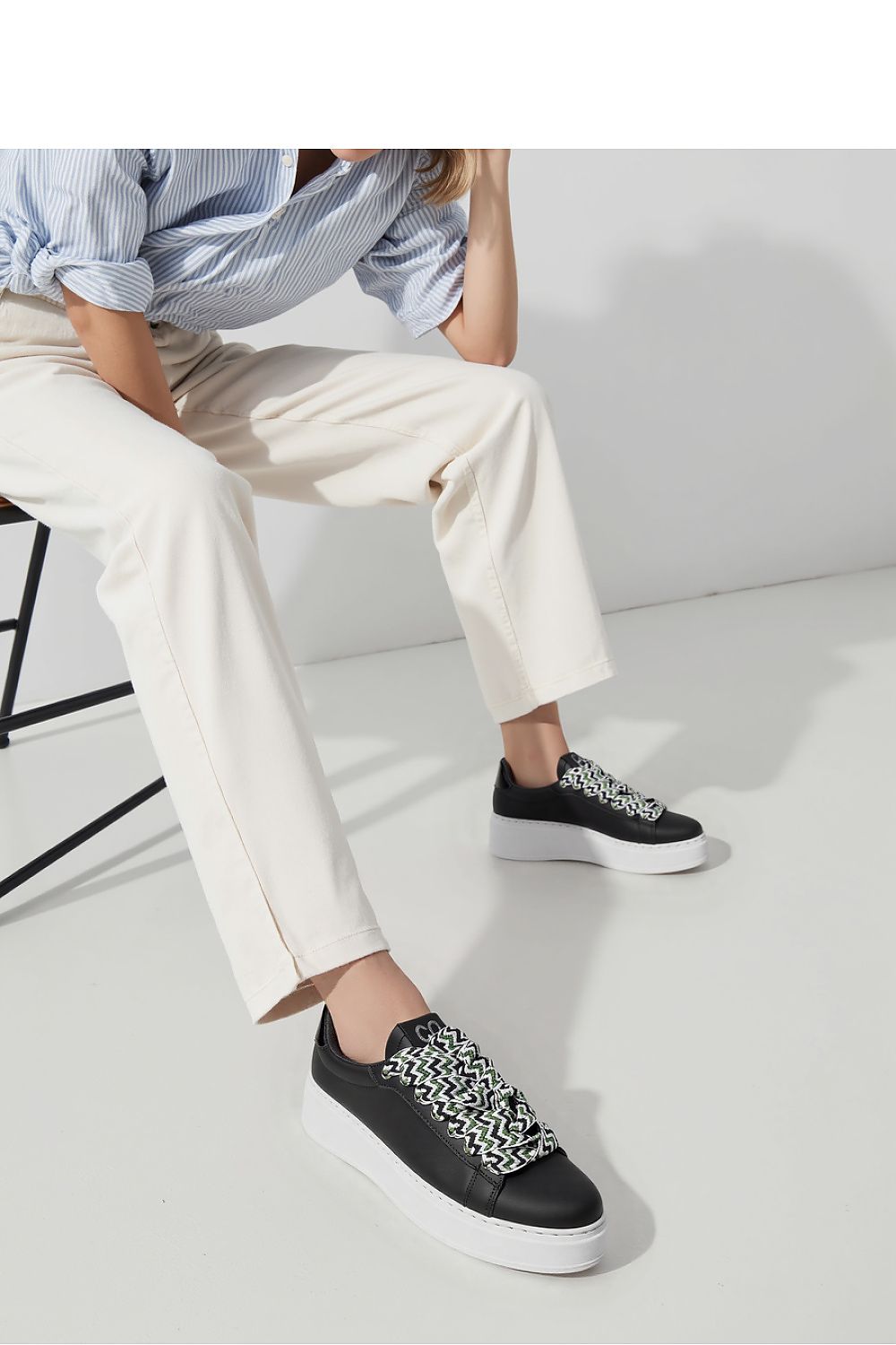 Elegant close-up of Zarax Black platform sneakers from Inello, showcasing the luxurious synthetic leather and intricate designer laces for a sophisticated urban look.