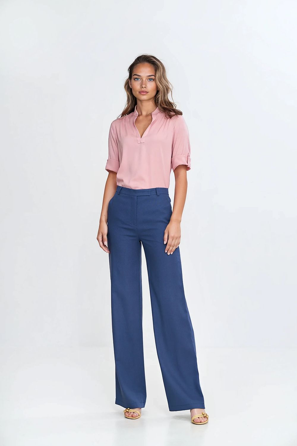 Detailed view of Nife's elegant high-waisted bootcut trousers, showcasing the zipper and button fastening with pleat detail.