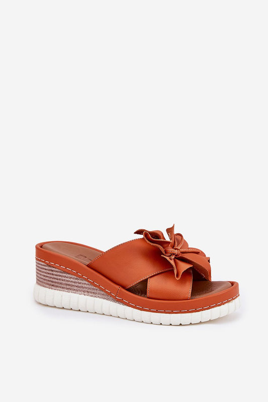Close-up of Step in Style luxury women's flip-flops showcasing the intricate flower detail on a natural leather wedge heel, depicting sophisticated summer fashion.
