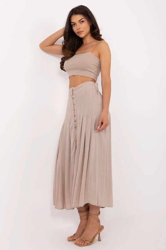 Close-up of the decorative buttons and smooth finish of Sublevel's eco viscose pleated midi skirt, highlighting luxury craftsmanship.