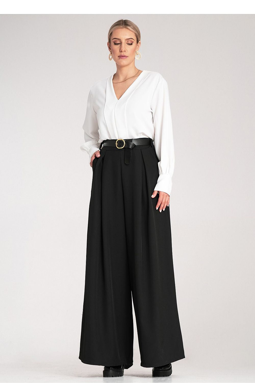 Elegant high-waisted palazzo trousers with a stylish black belt, designed for women by Figl. These luxurious wide-leg trousers feature a delicate fabric, slit pockets, and an elastic waistband, perfect for sophisticated occasions.