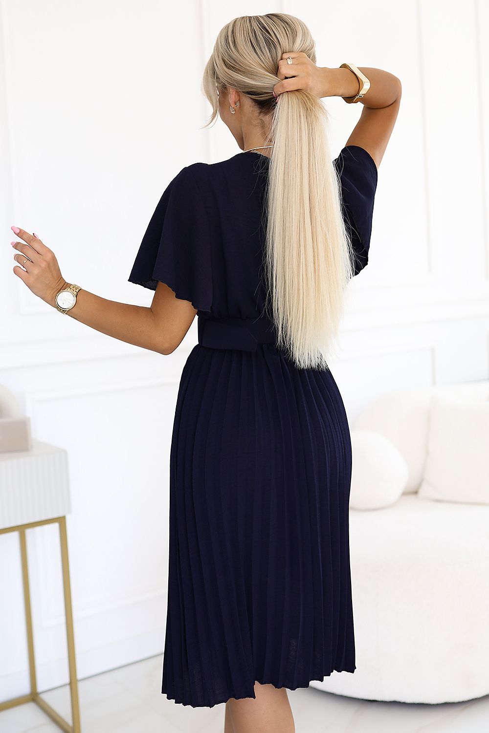 Close-up of the LYRA Daydress by Numoco highlighting its pleated bottom and luxurious fabric details, ideal for adding a touch of elegance to any wardrobe.