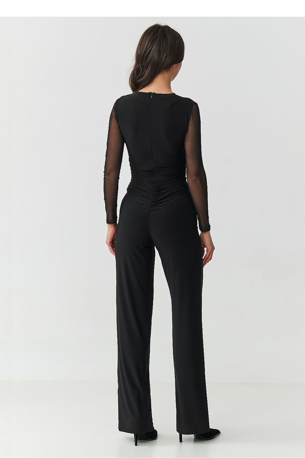 Model wearing the Makadamia elegant black jumpsuit with tulle details, a sophisticated choice for cocktail parties and upscale events.