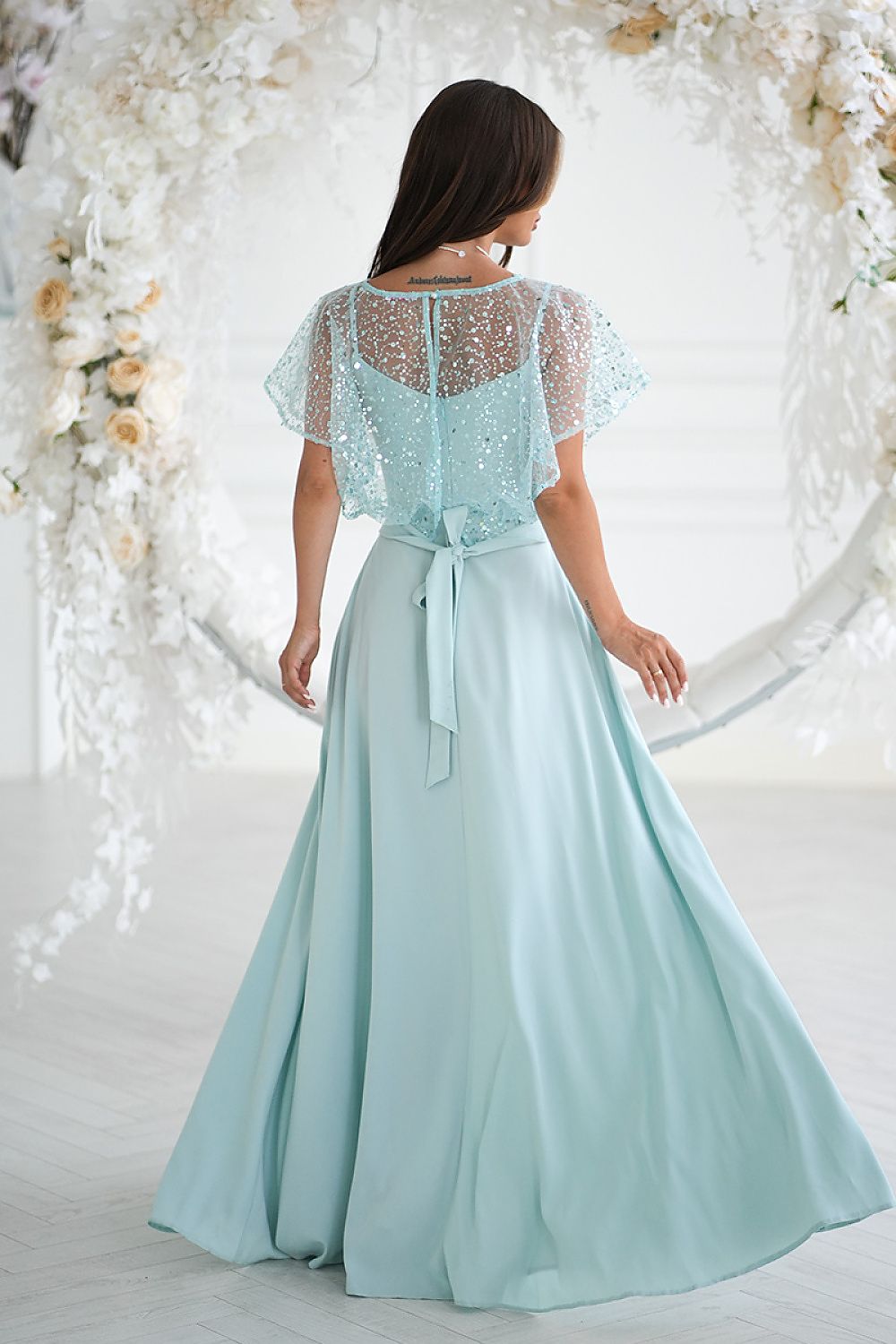 Bicotone close-up of sequin bolero on elegant long dress, showcasing luxurious details perfect for evening wear and special events.