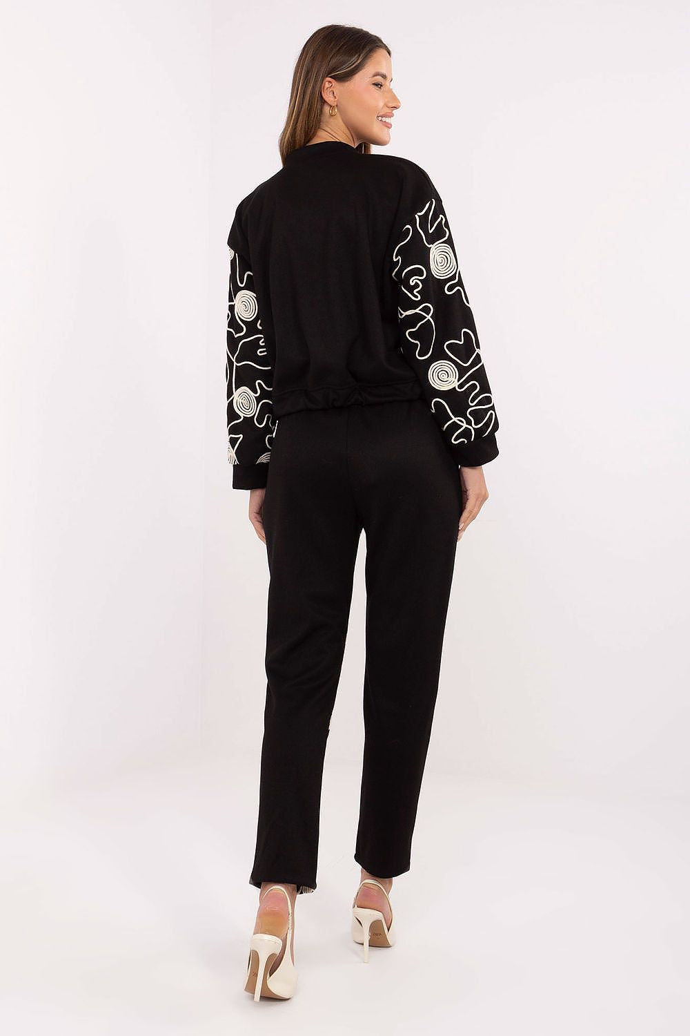 Close-up view of the Italy Moda women's stylish tracksuit highlighting the beautiful embroidery details on the hoodie sleeve and pant leg, showcasing premium craftsmanship.