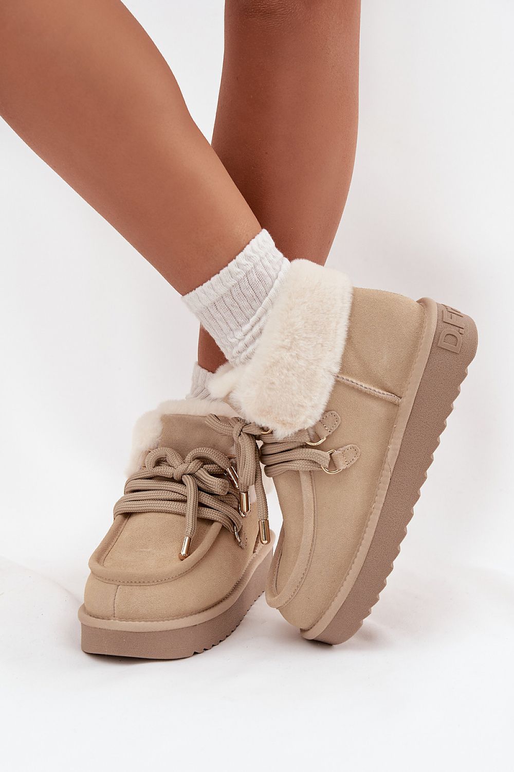 D.Franklin women's stylish snow boots displayed on a snowy background, highlighting their modern low silhouette and durable rubber sole for elegant winter outings, from Step in Style.