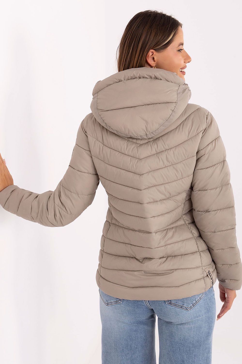 Zippered pockets on the Sublevel women's quilted transitional jacket, adding functionality to its elegant and modern design.