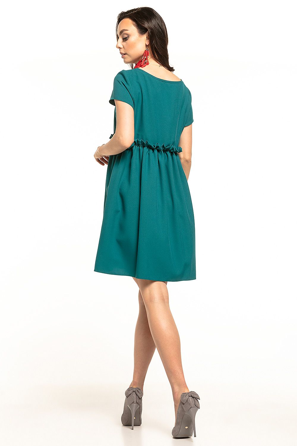 Back view of the elegant mini daydress Tessita, featuring a boat neckline and ruffled detail, in a rich teal colour, complemented by stylish grey high heels. Ideal for versatile occasions.