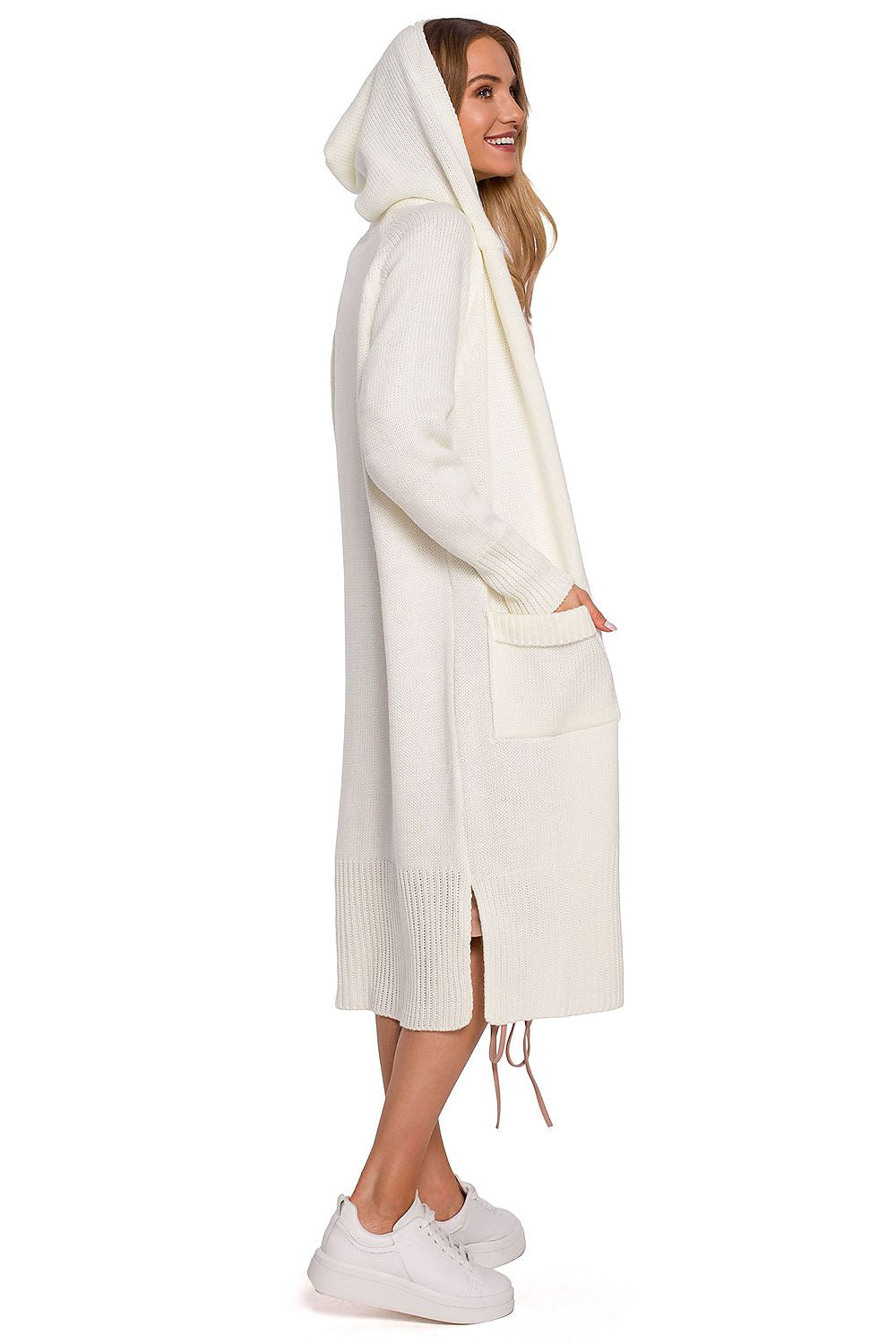 Profile view of the luxurious white long cardigan with fitted hood, pockets, and side slits by Moe, accentuating its fashionable silhouette worn by a model.