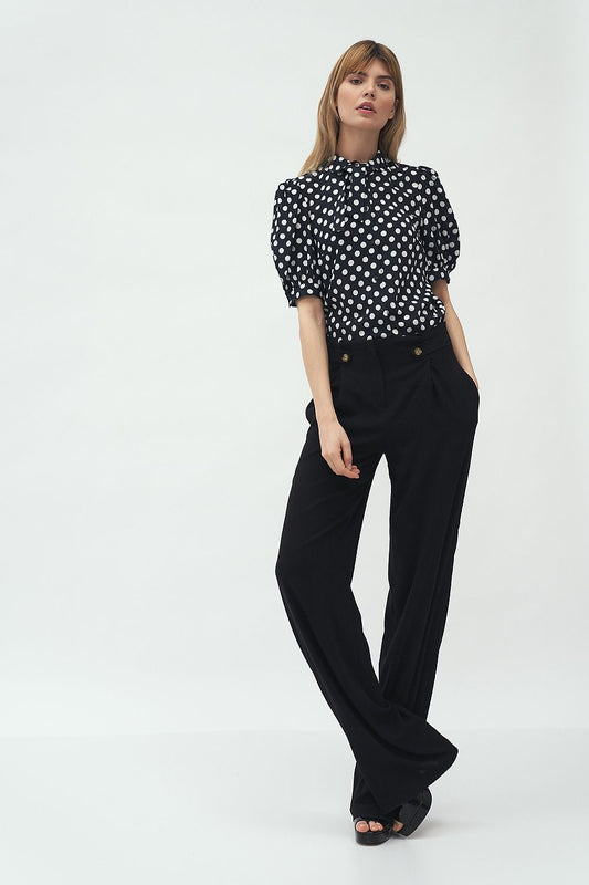 Elegant short sleeve shirt by Nife, featuring a black and white polka dot pattern, styled with wide-leg trousers, perfect for casual sophistication.