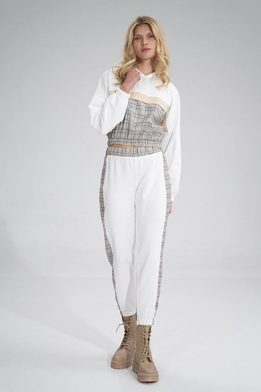 Fashionable perspective of a woman wearing Figl tracksuit trousers, showcasing the trendy plaid and white design, exuding elegance and comfort.