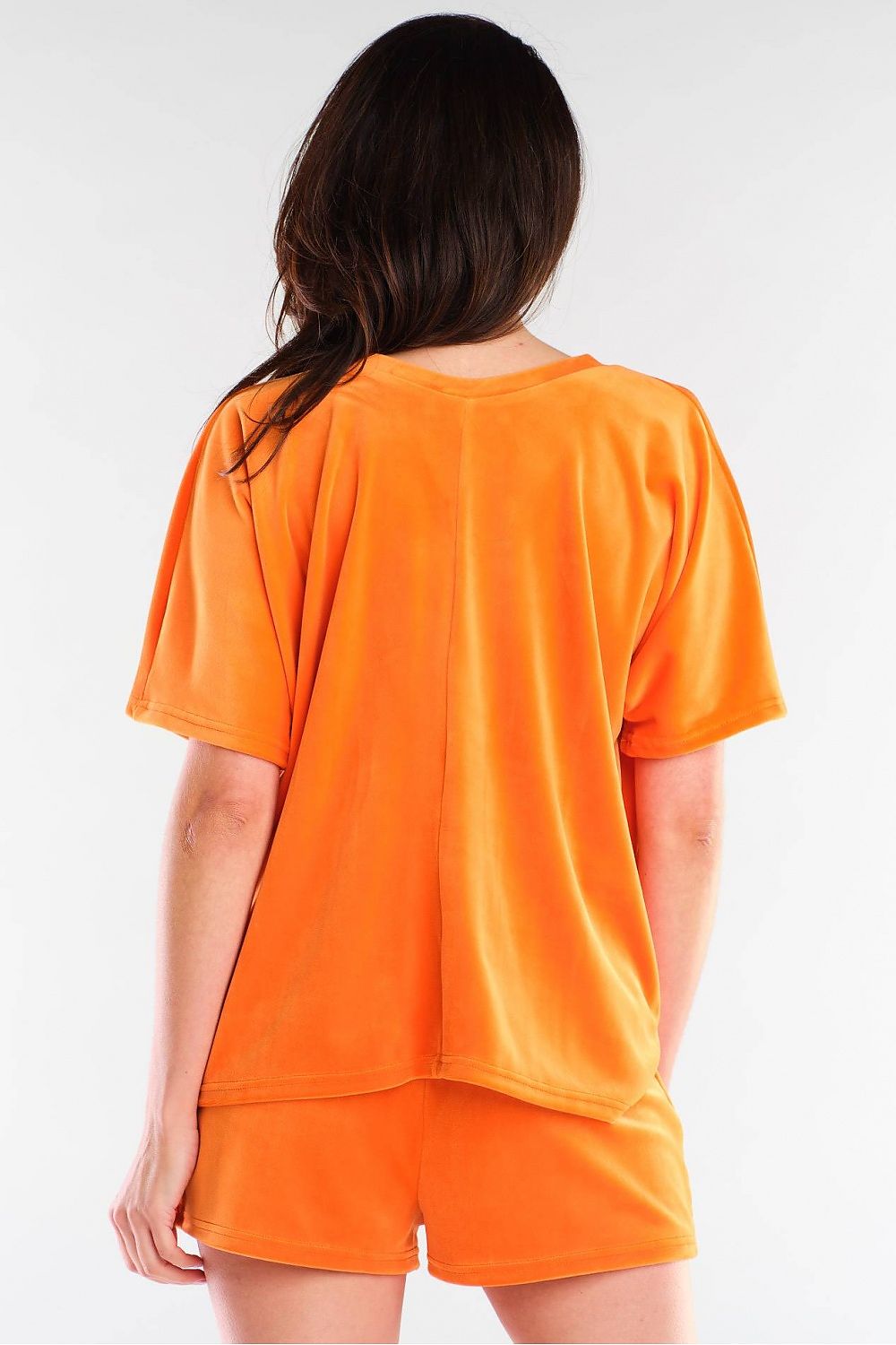 Back view of Awama's luxurious orange velour shorts, showcasing the soft fabric and relaxed fit, ideal for stylish comfort.