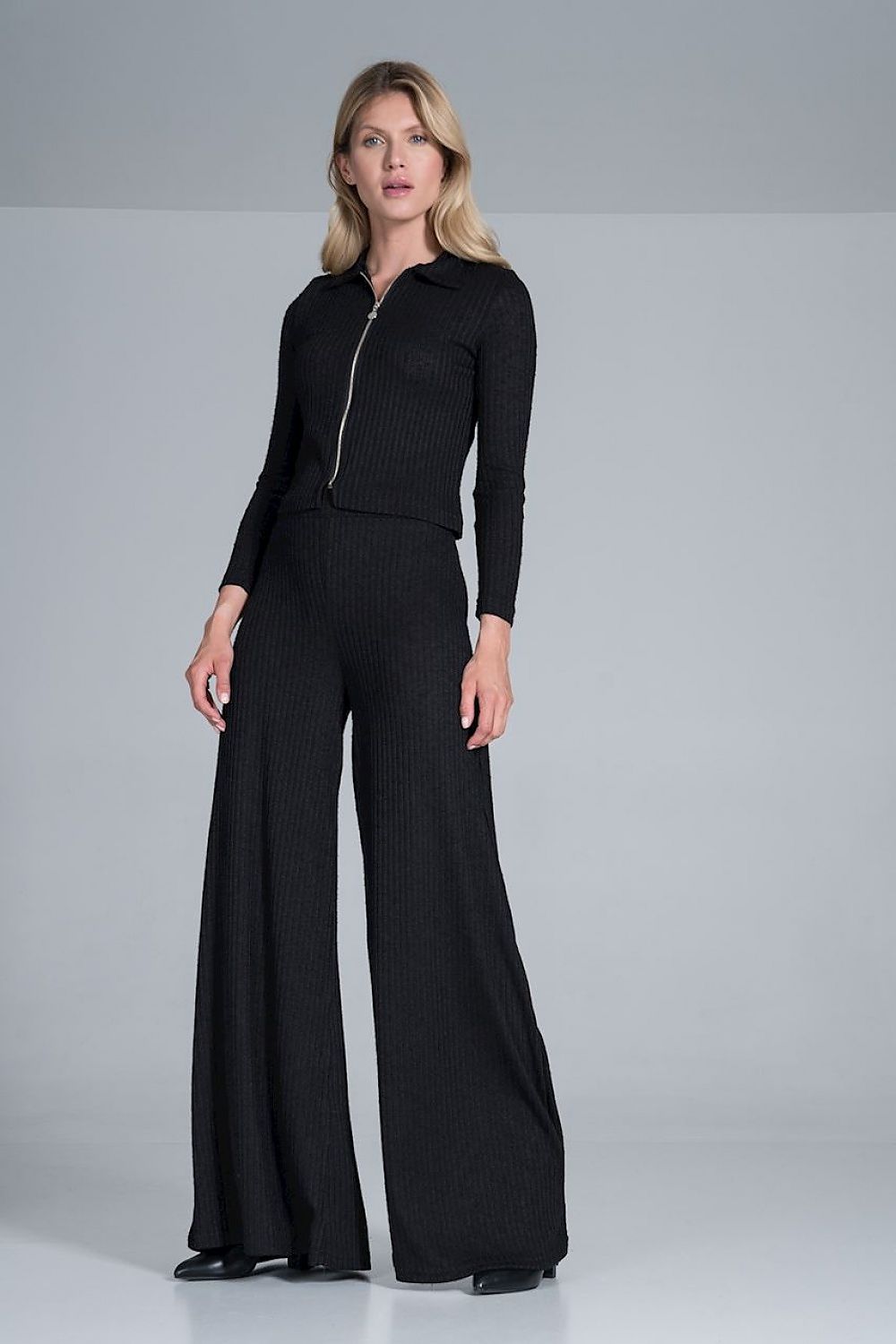 Close-up of Figl Women's Luxury Ribbed Knit Blouse With Collar and Front Zip Fastening, Long Sleeves, featuring a modern look complemented by stylish wide pants in a rich black shade.