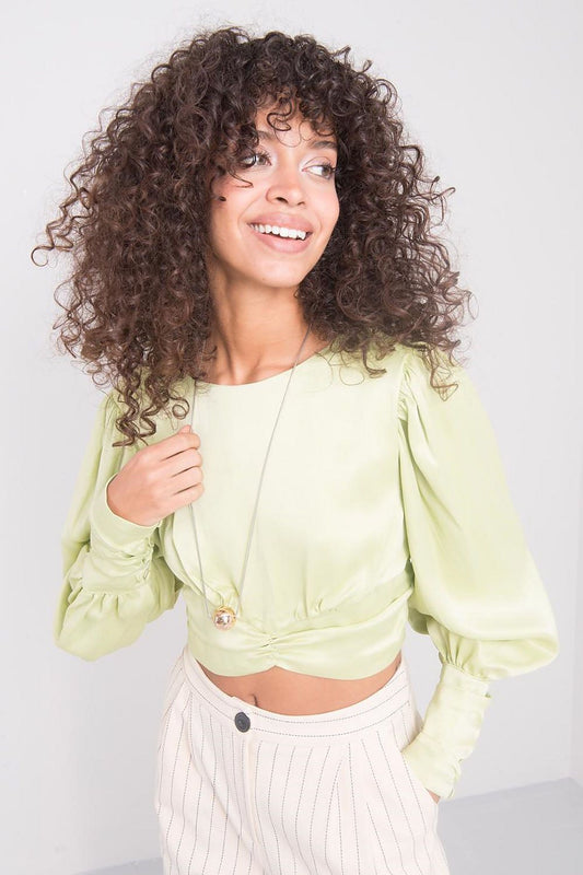 Charming model wearing a lime long sleeve viscose blouse with distinctive back detail by Sally Fashion, effortlessly accentuating her style alongside tailored striped trousers for a luxury look.