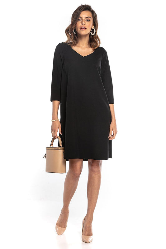 Chic black trapeze dress with 3/4 sleeves and a graceful pointed neckline, styled with a decorative belt, presented by Tessita for an upscale fashion statement.