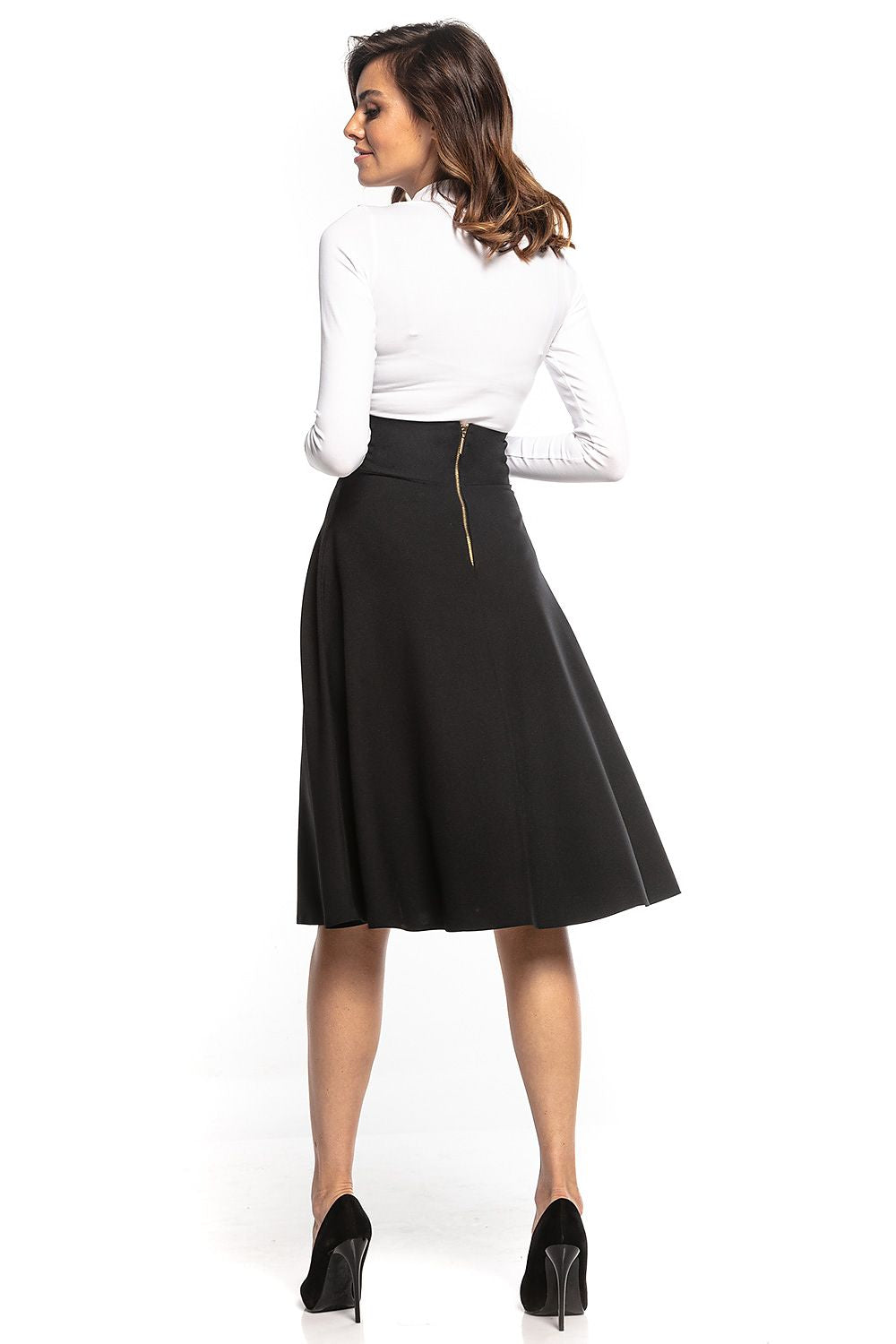 Back view of Tessita high-waisted black midi skirt with decorative zipper, paired with a chic white long-sleeve top, epitomising timeless elegance.